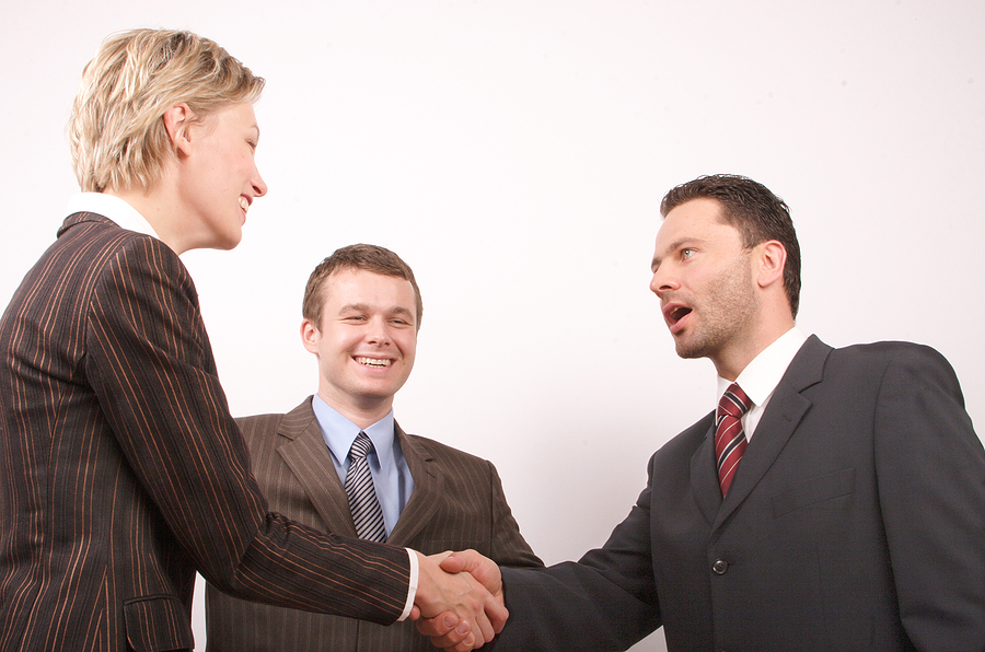 Group of three business people - man and woman hand shake