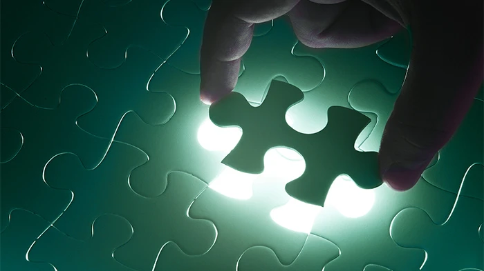 hand placing a green puzzle piece